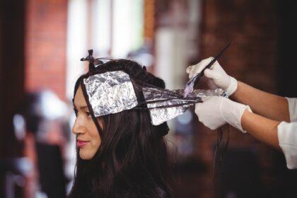 Hairdresser dyeing hair of her client